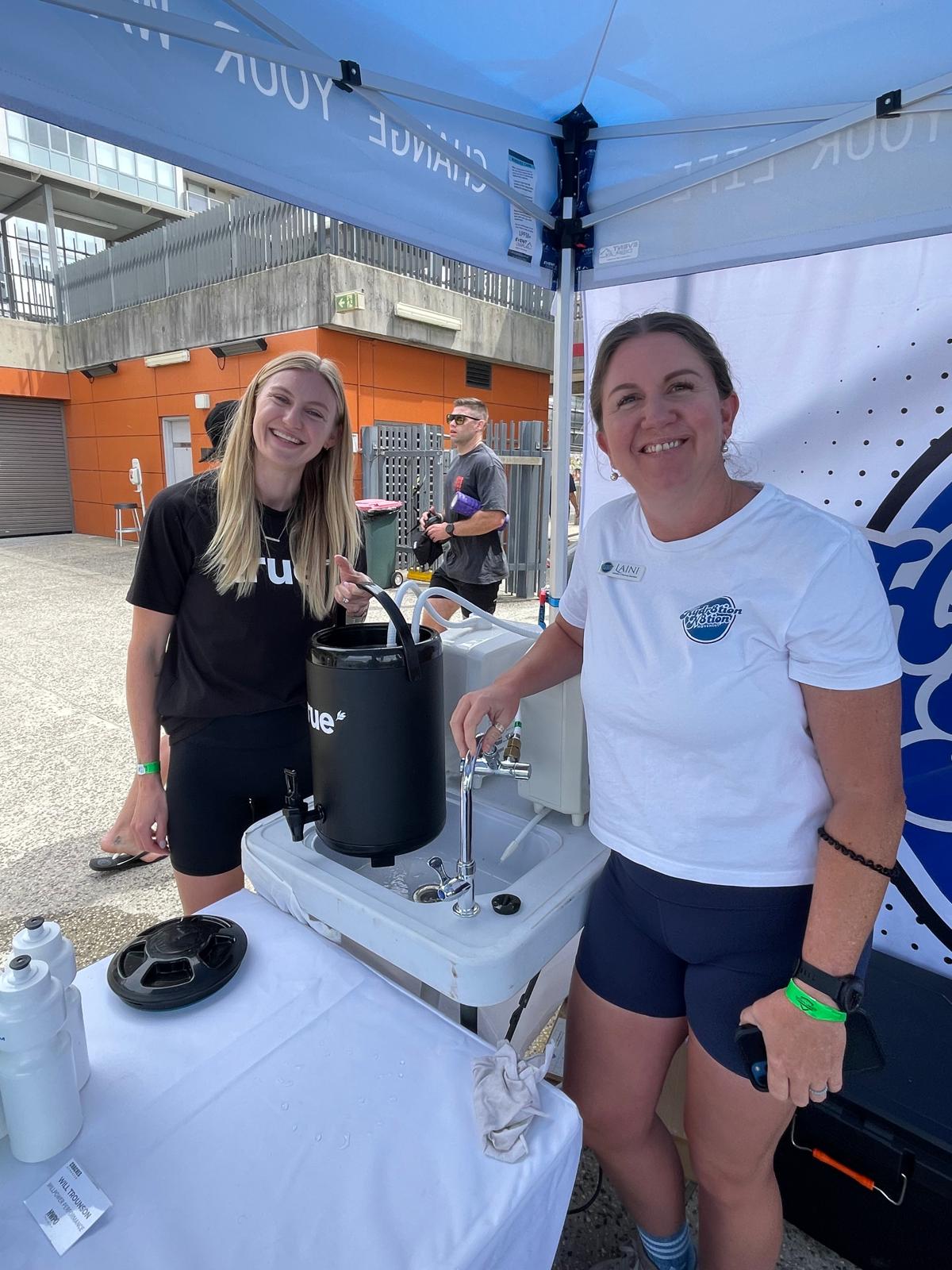 Hydr8tion N8tion team member with an attendee at an outdoor event booth