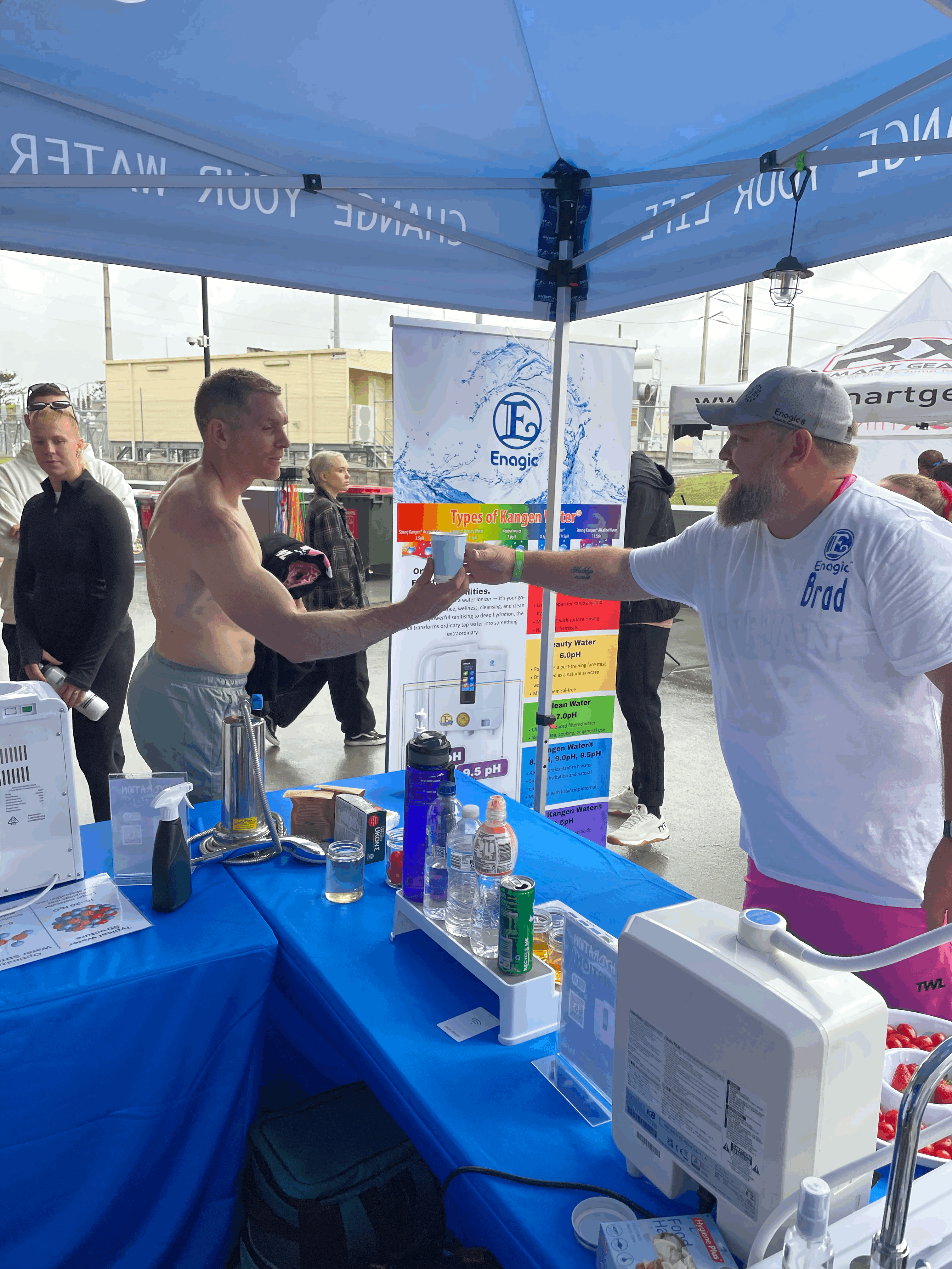 Attendee taking a cup from a Hydr8tion N8tion team member at the Torian Pro stand